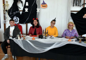 cztery osoby w przebraniach siedzące przy stole