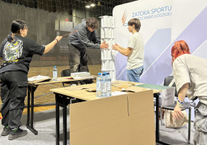 Zawodnicy ustawiają wierzę z papieru