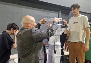 Zawodnicy ustawiają wierzę z papieru